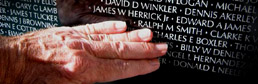 Fingers touching James W Herrick Jr's name on the Wall